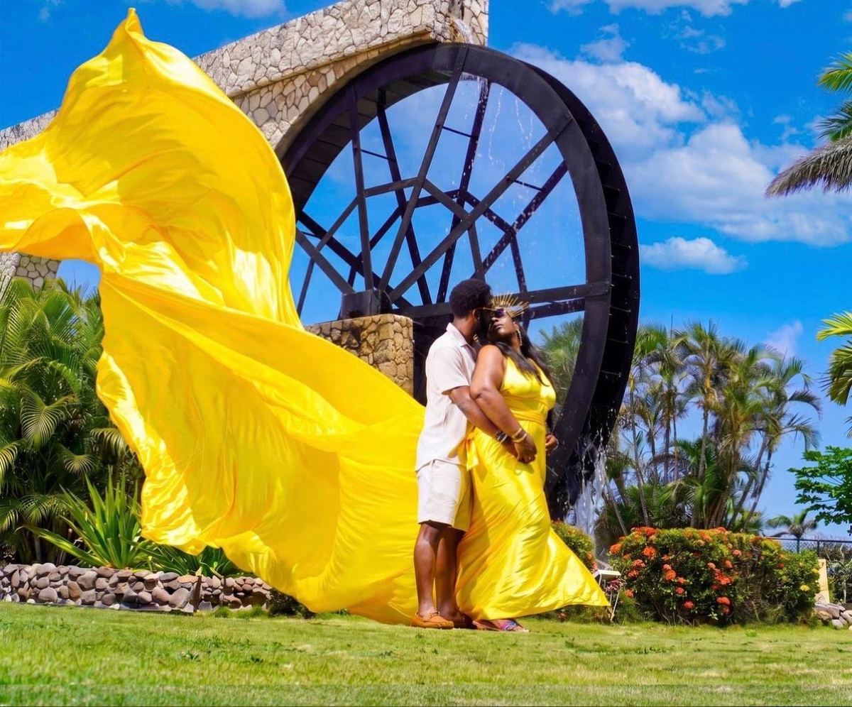 Couple in a flying dress photoshoot by a water wheel