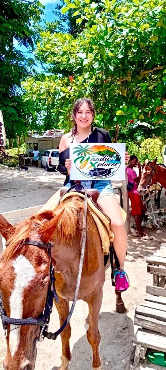 Smiling guest on horseback with the Yaadie Xplorer sign